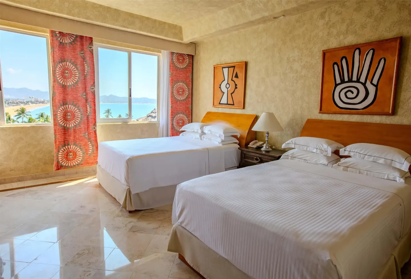 Guest room with two beds and ocean view windows at Barceló Karmina.