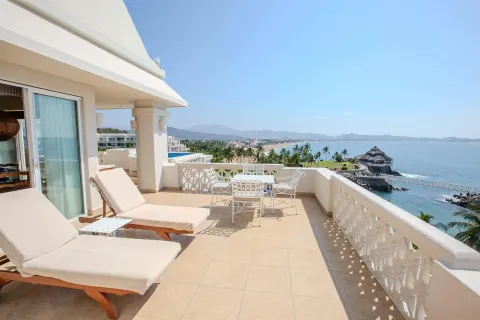 Ocean-view terrace with loungers and dining set at Barceló Karmina.