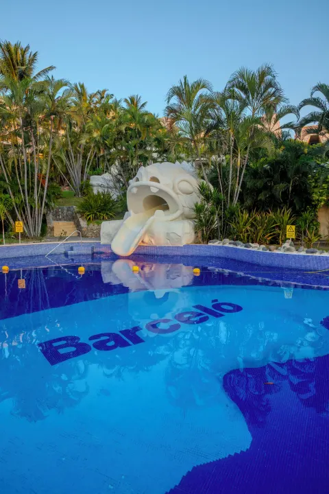 Pool with a sculpted water slide and Barceló tile lettering at Barceló Karmina.