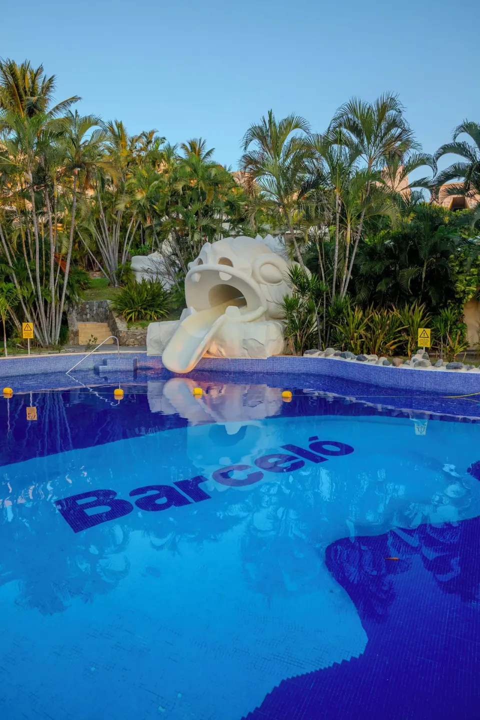 Pool with a sculpted water slide and Barceló tile lettering at Barceló Karmina.