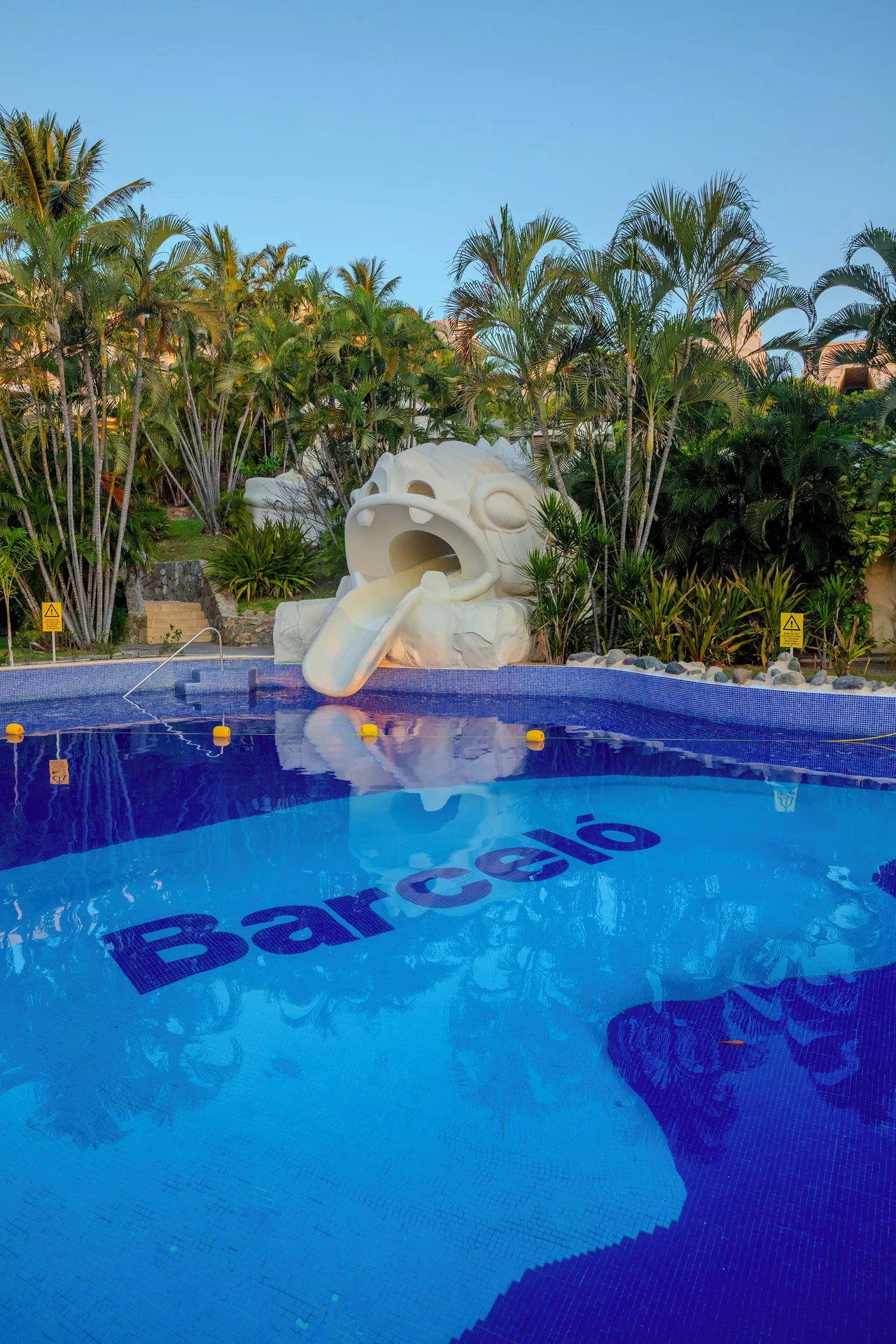 Pool with a sculpted water slide and Barceló tile lettering at Barceló Karmina.