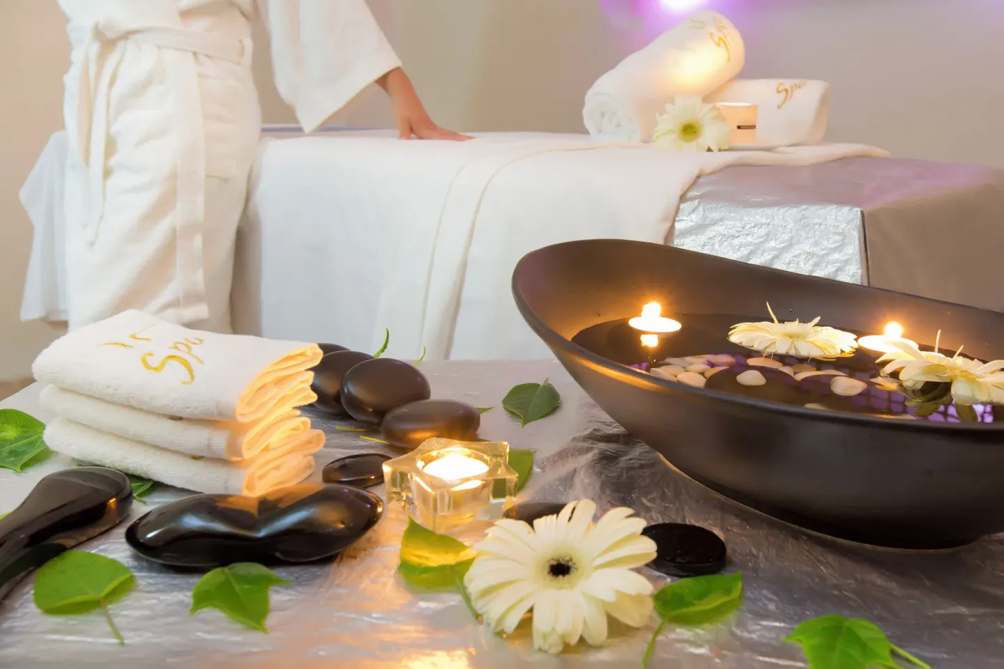 Spa treatment table with candles, flowers, towels, and hot stones at Barceló Karmina.