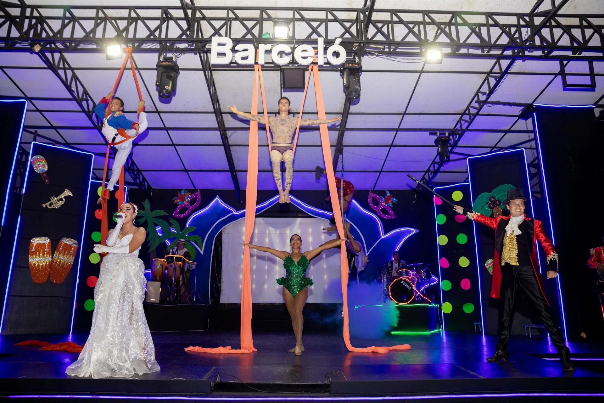 Aerial performers and entertainers appear on a lit stage at Barceló Karmina.