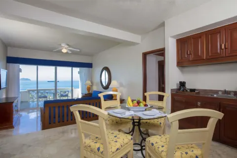 Suite living and dining area with ocean-facing balcony at Barceló Karmina.