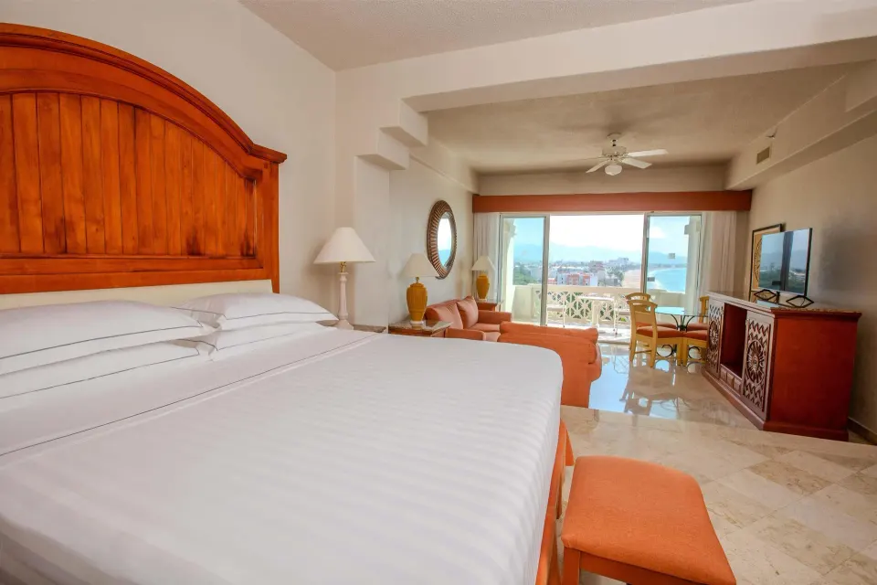 Junior Suite Premium Level king bed and ocean-view balcony at Barceló Karmina.