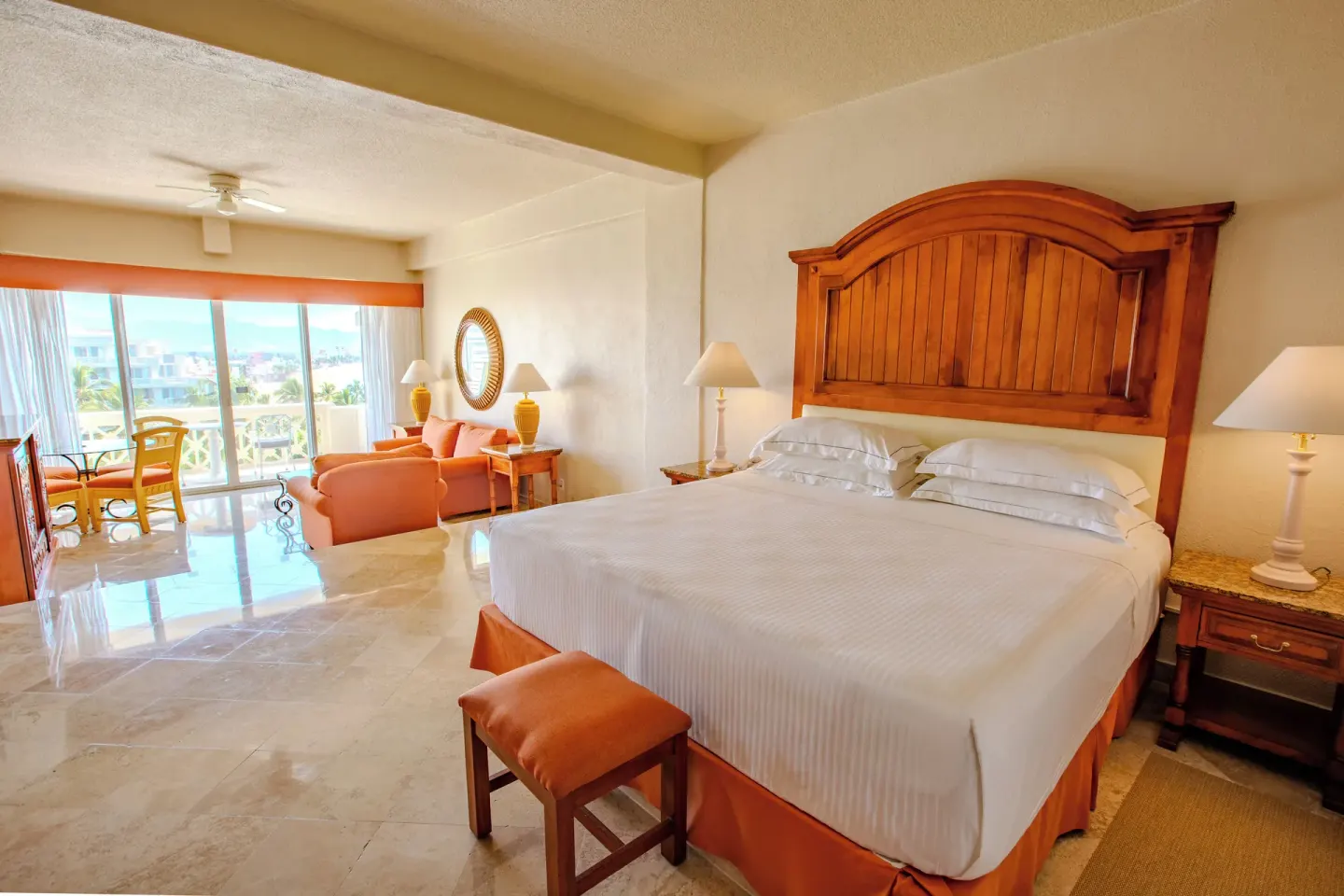 Junior Suite Sea View king bed and sitting area at Barceló Karmina with balcony beyond.