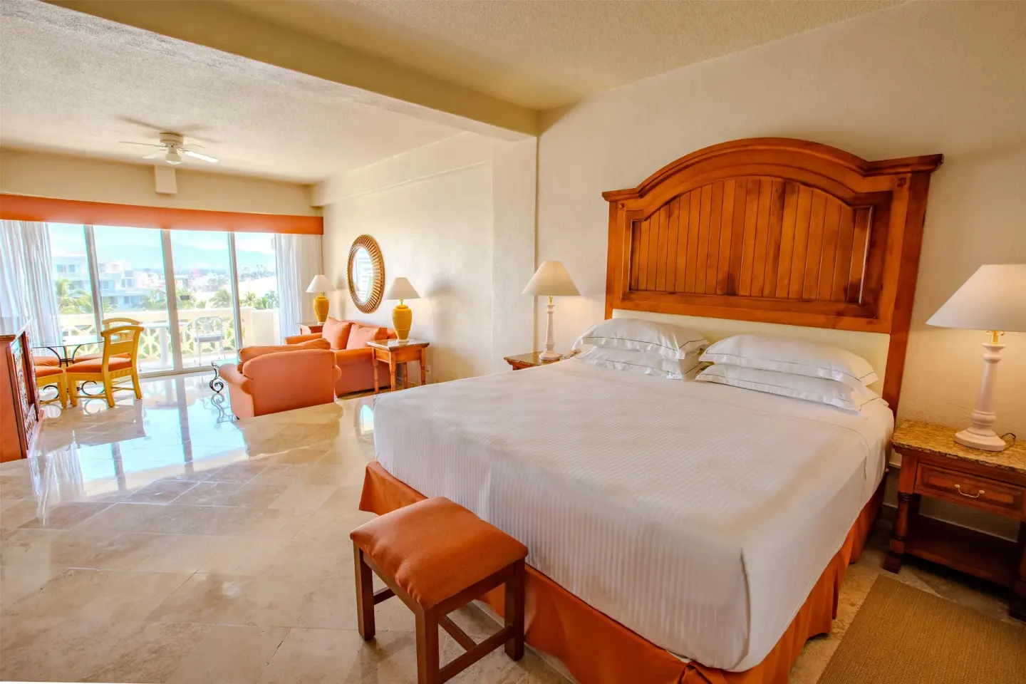 Junior Suite Sea View king bed at Barceló Karmina with wood headboard and lounge seating.