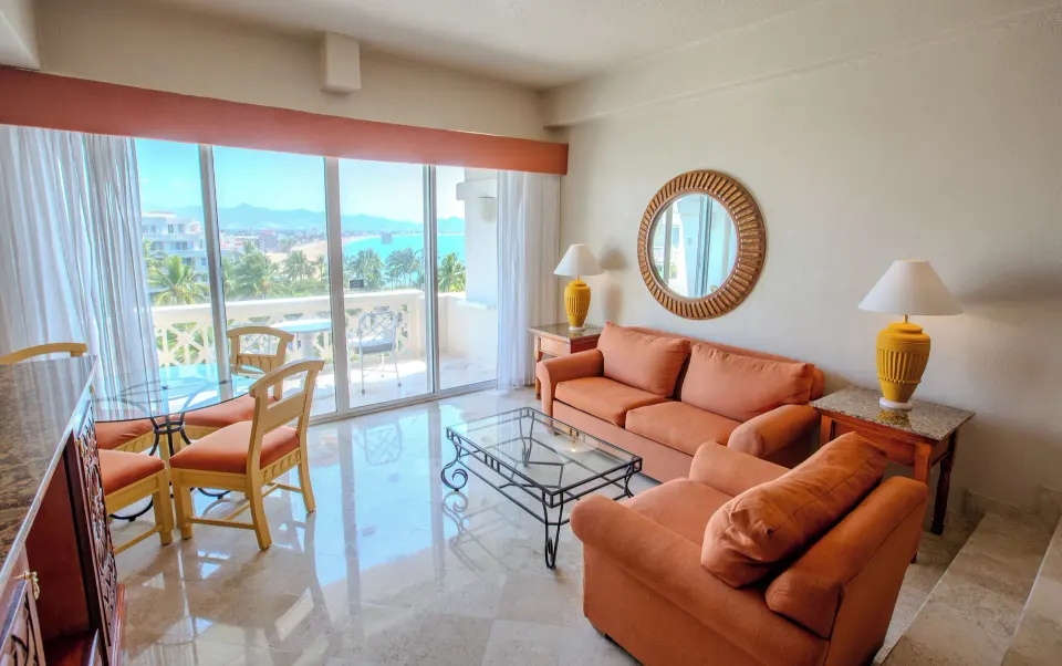 Junior Suite Sea View sitting area at Barceló Karmina with sofa, table and ocean beyond the balcony.