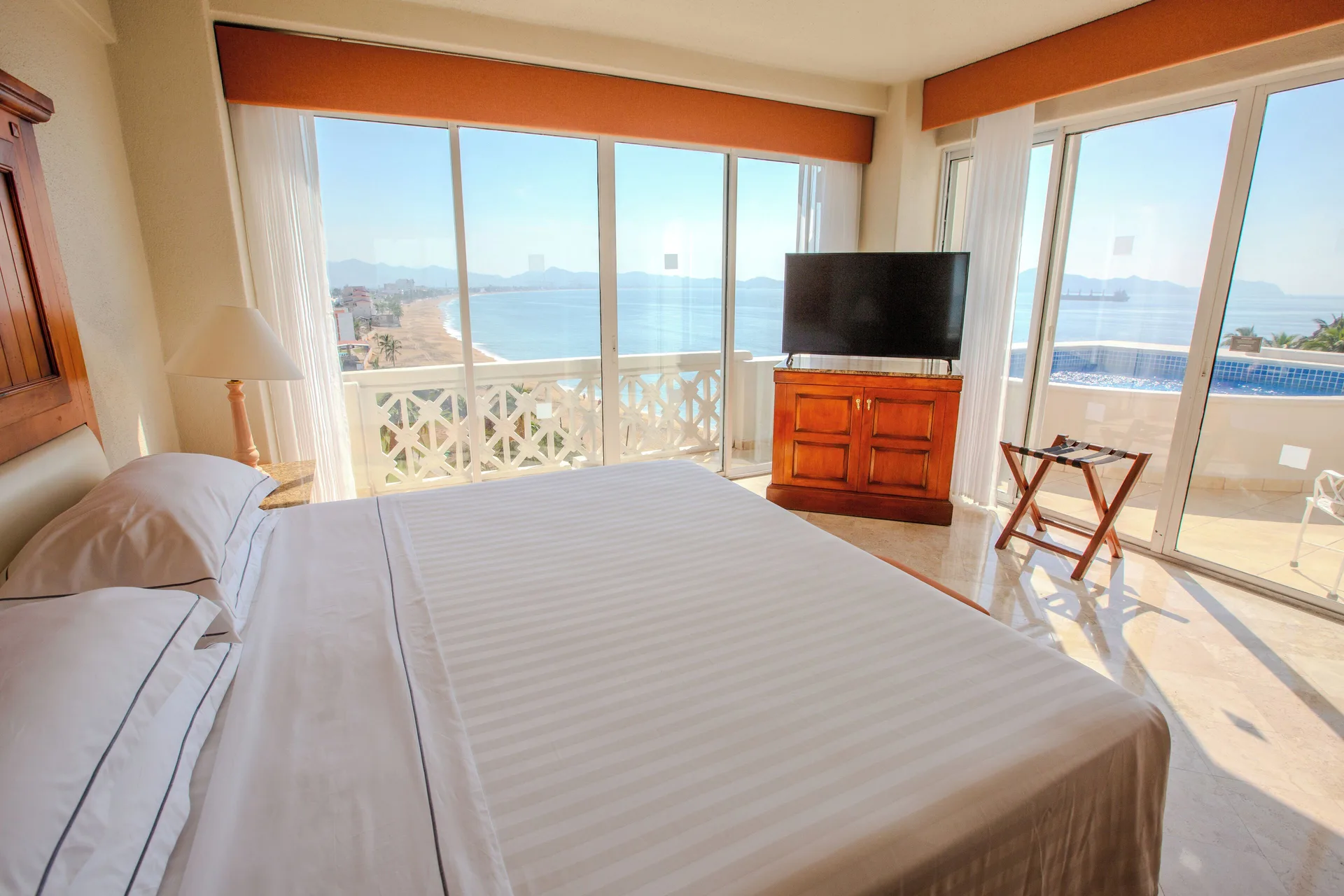 Master Suite bedroom with king bed, TV, balcony pool and sea view at Barceló Karmina.