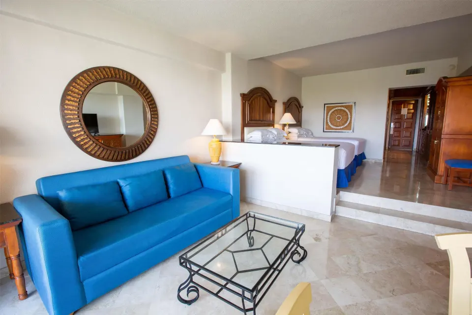 Suite Garden View seating area with blue sofa and raised beds at Barceló Karmina.