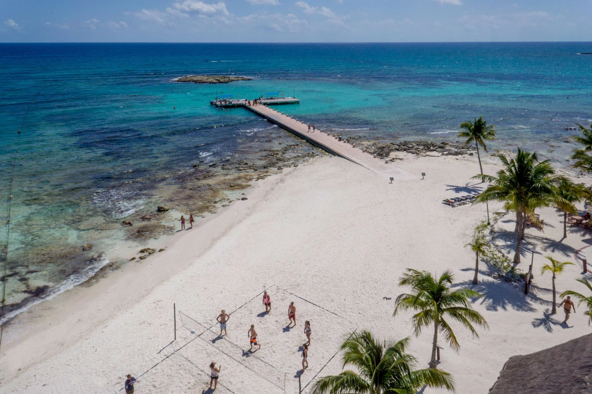 Aerial view of the beach, pier, reef, and volleyball court at Barceló Maya Caribe.