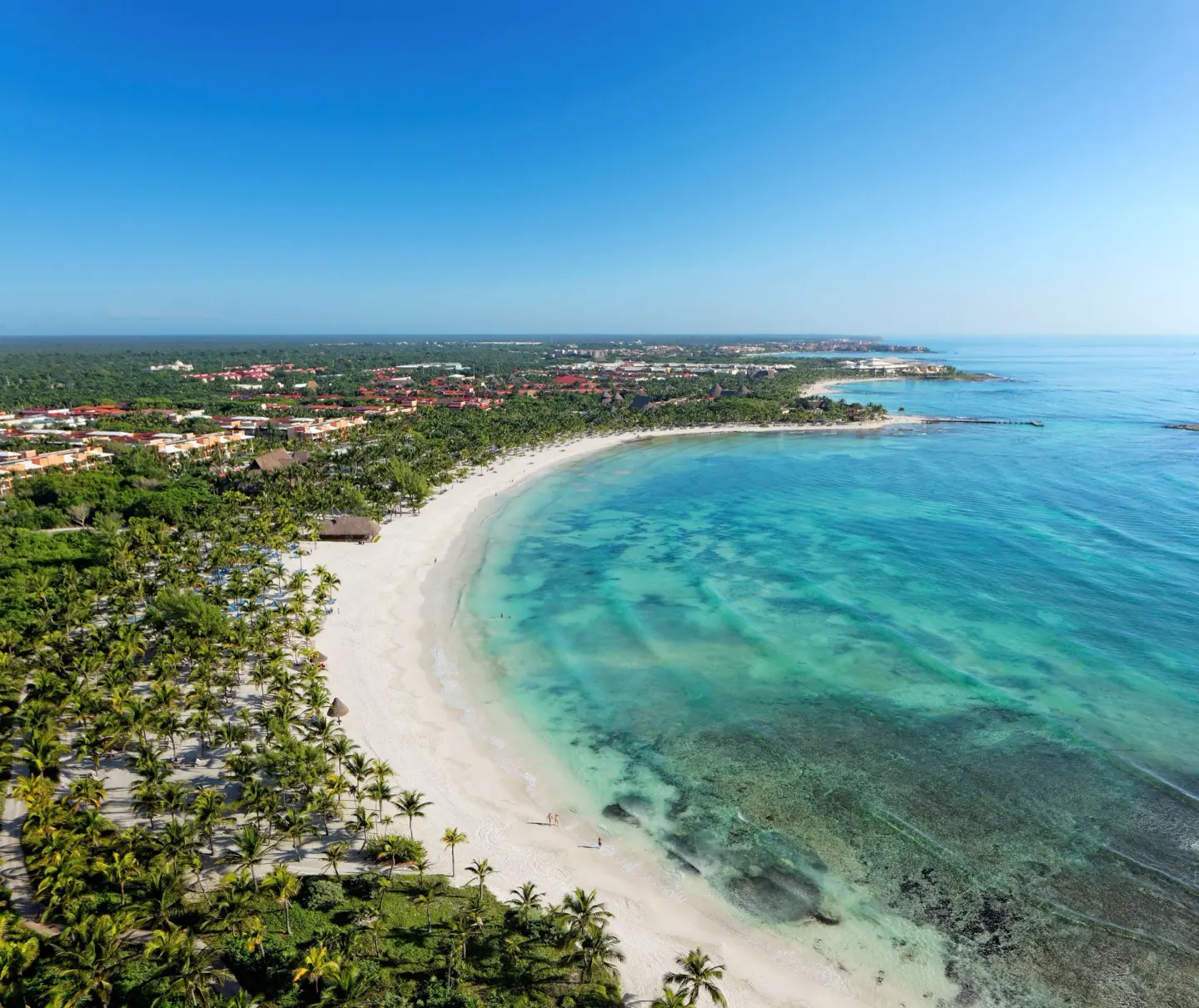 Aerial coastline view shows the beach and turquoise bay at Barceló Maya Caribe.