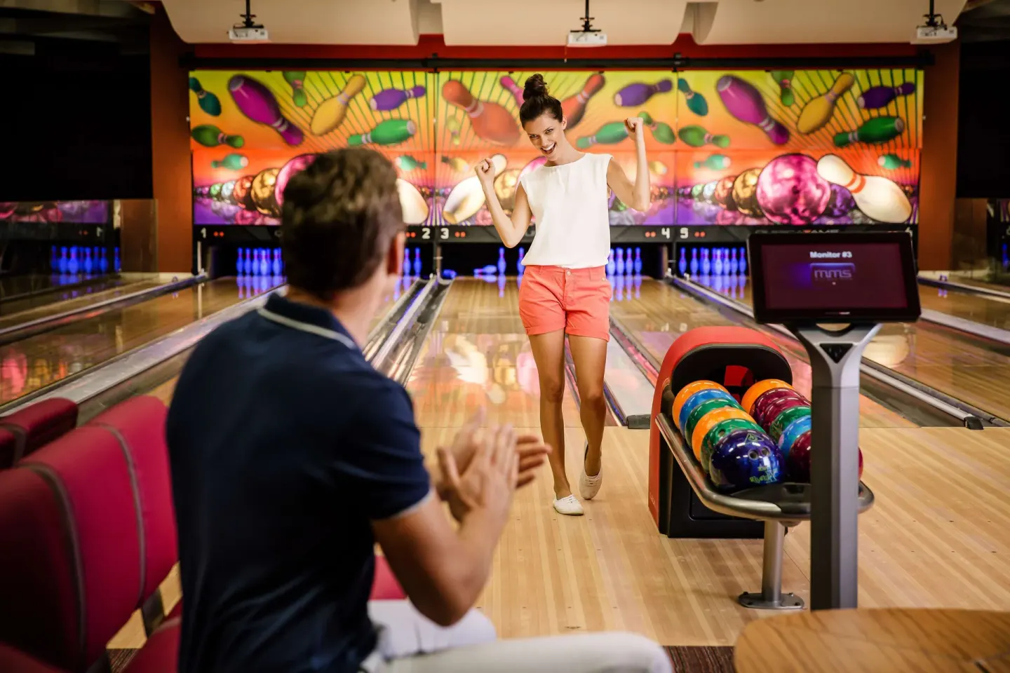 A guest celebrates beside bowling lanes at Barceló Maya Caribe.