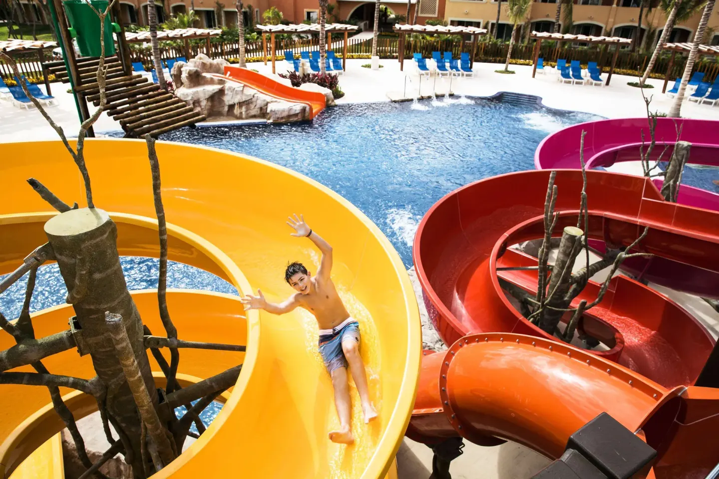 A child slides down colorful water slides into the pool at Barceló Maya Caribe.