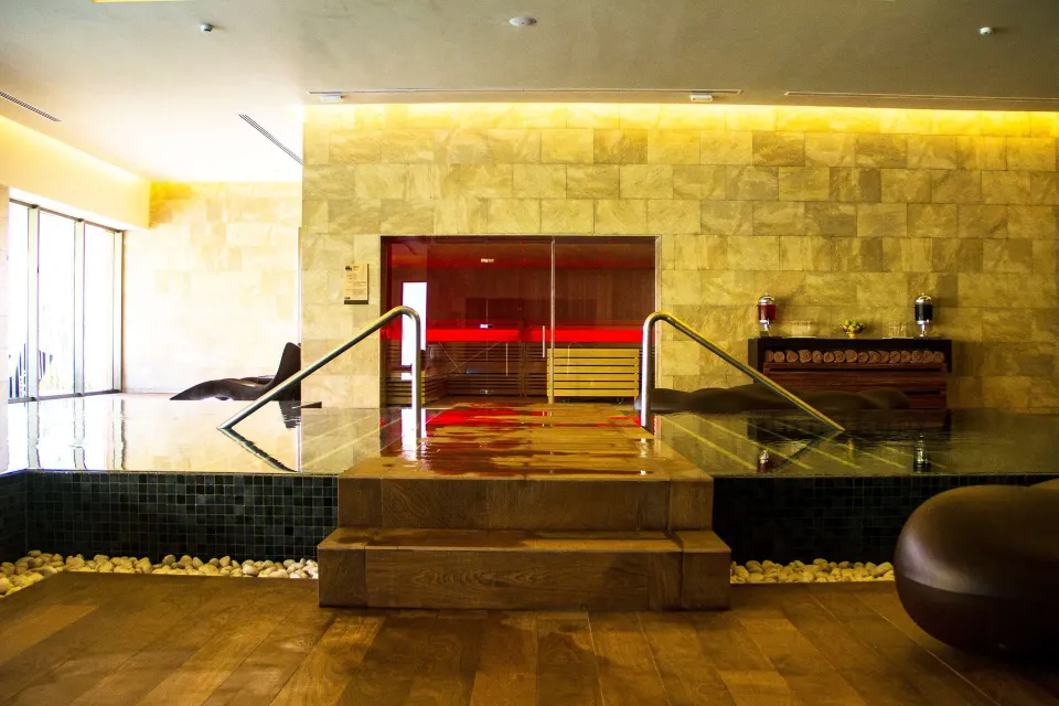 Indoor spa pool with steps and a sauna room behind it at Barceló Maya Caribe.