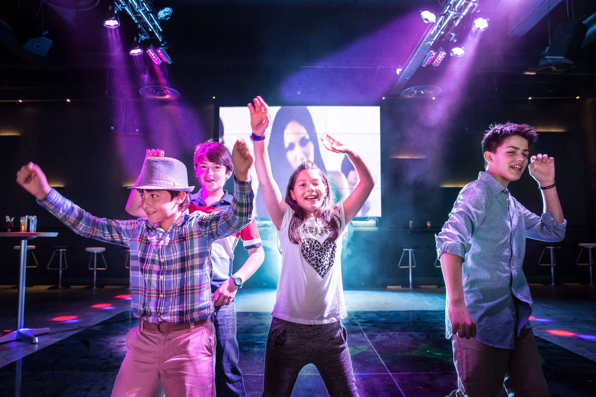 Children dancing under purple club lights at Barceló Maya Caribe.