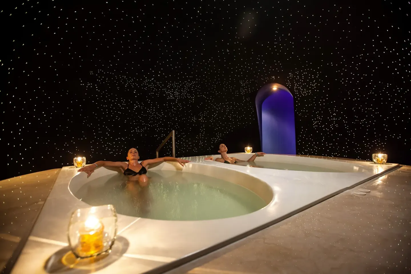 Guests relaxing in round spa pools under a starry ceiling at Barceló Maya Caribe.