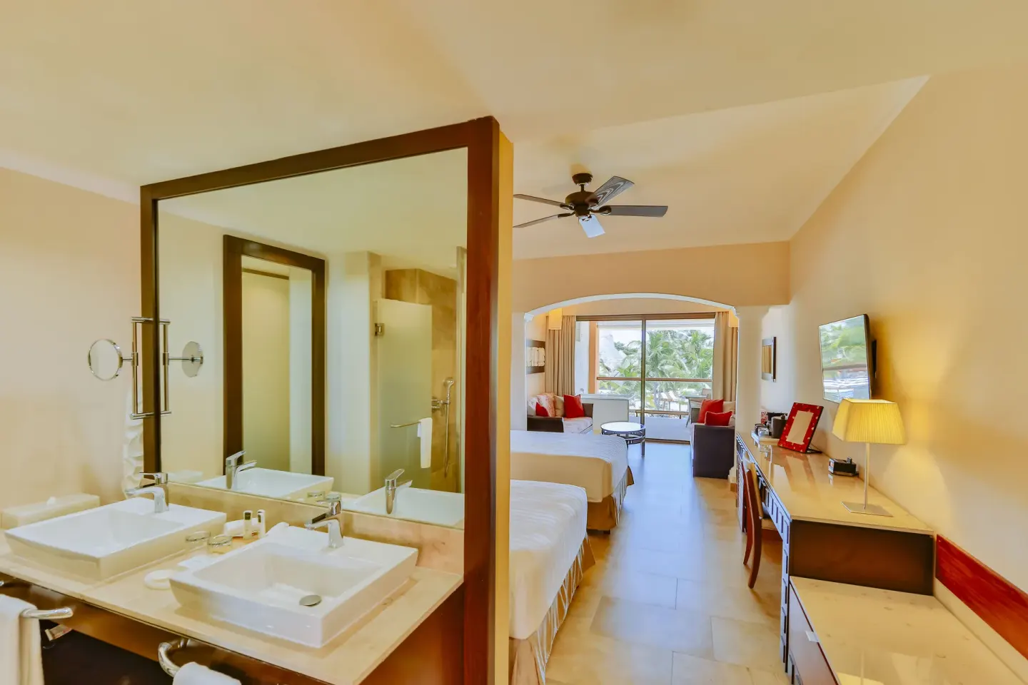 Junior Suite bathroom and bedroom with two beds at Barceló Maya Caribe.