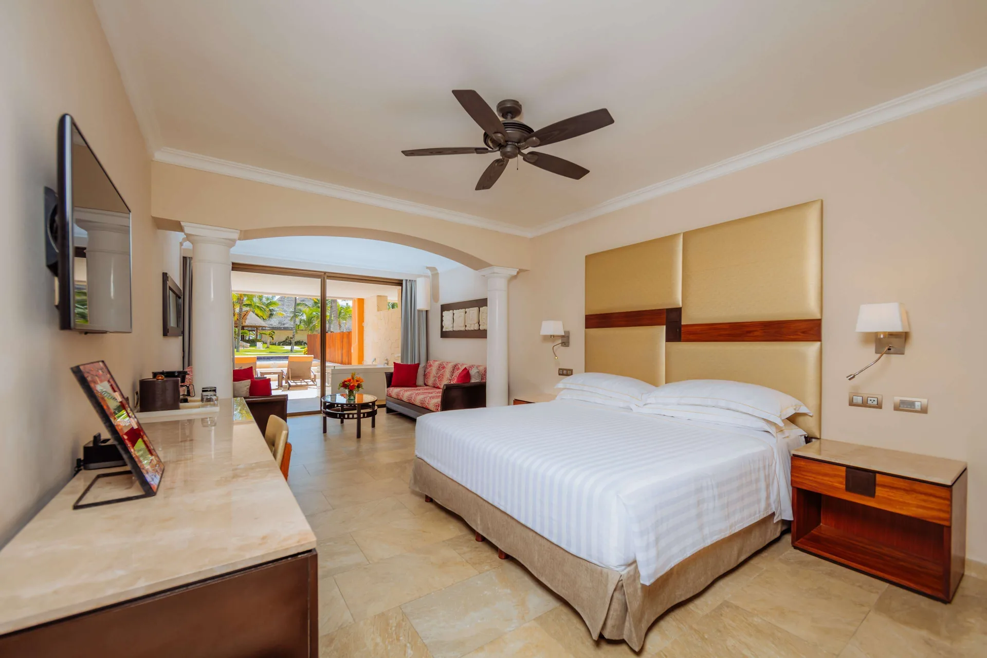 Junior Suite swim-up room with king bed, sofa, and terrace doors at Barceló Maya Caribe.