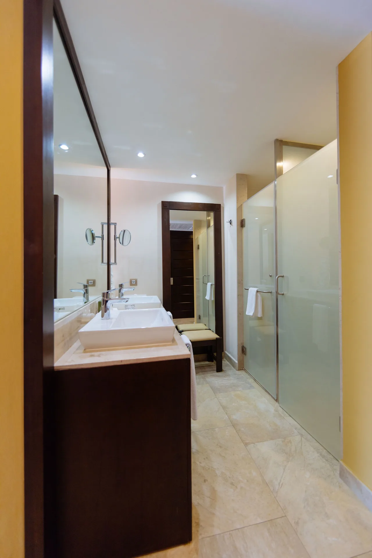 Junior Suite Swim Up Premium Level bathroom with long vanity and shower at Barceló Maya Caribe.