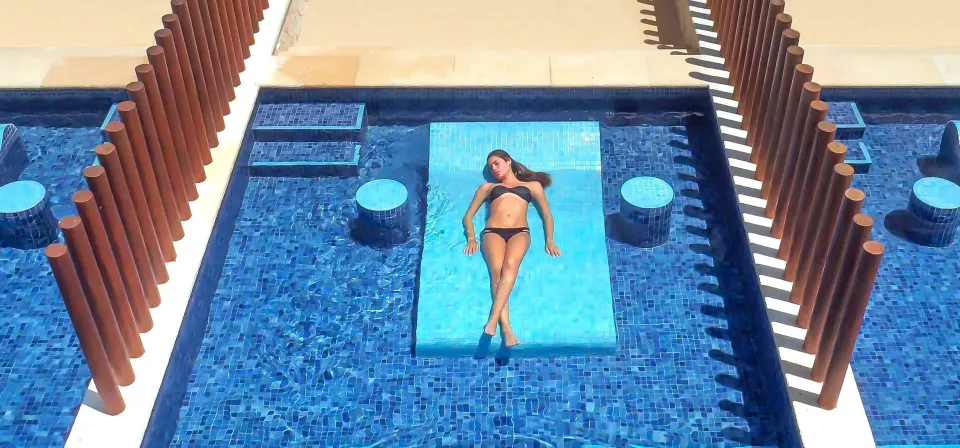 Junior Suite swim-up pool ledge with blue tile and privacy screens at Barceló Maya Caribe.