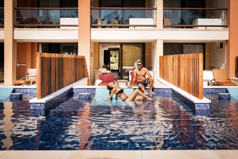 Junior Suite swim-up pool terrace with guests outside Barceló Maya Caribe.