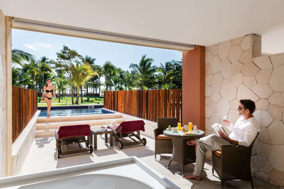 Junior Suite swim-up terrace with dining table, loungers, and pool at Barceló Maya Caribe.
