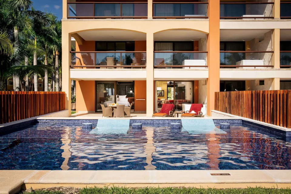 Ground-floor swim-up suite terrace facing a blue pool at Barceló Maya Caribe.