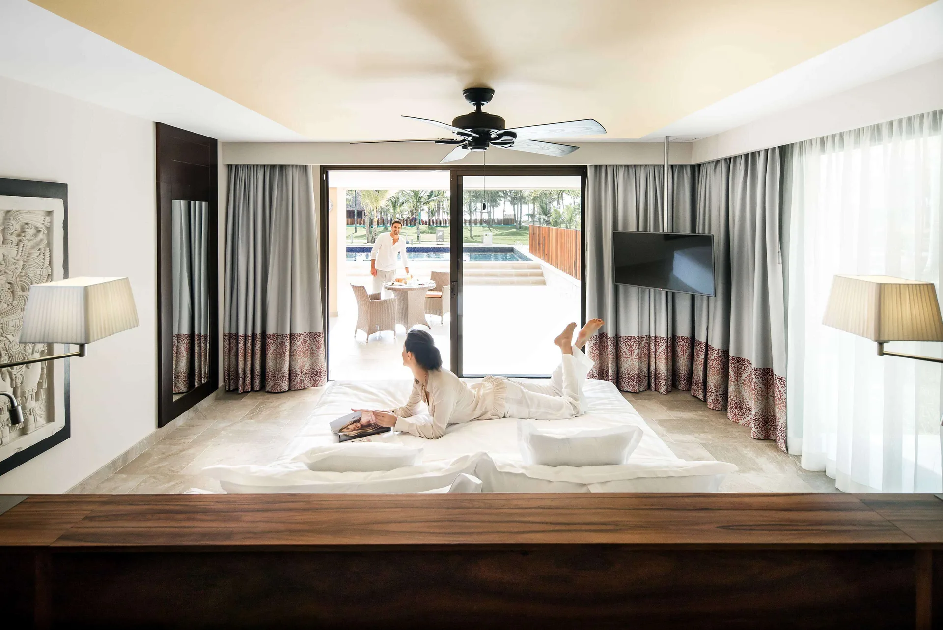 Swim-up suite bedroom with king bed and terrace doors at Barceló Maya Caribe.