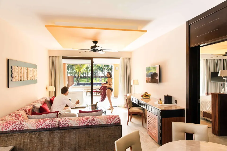 Swim-up suite living area with sofa, desk, and terrace at Barceló Maya Caribe.
