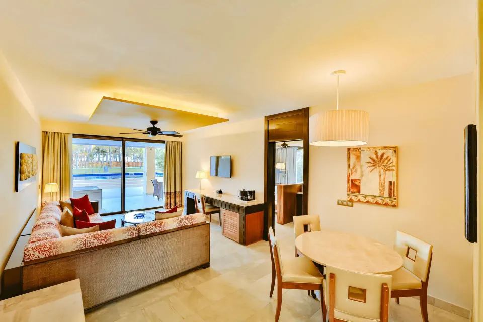 Suite living and dining area with terrace pool view at Barceló Maya Caribe.