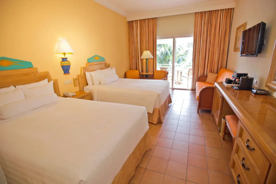 Superior Room with two beds, balcony doors, and seating at Barceló Maya Caribe.