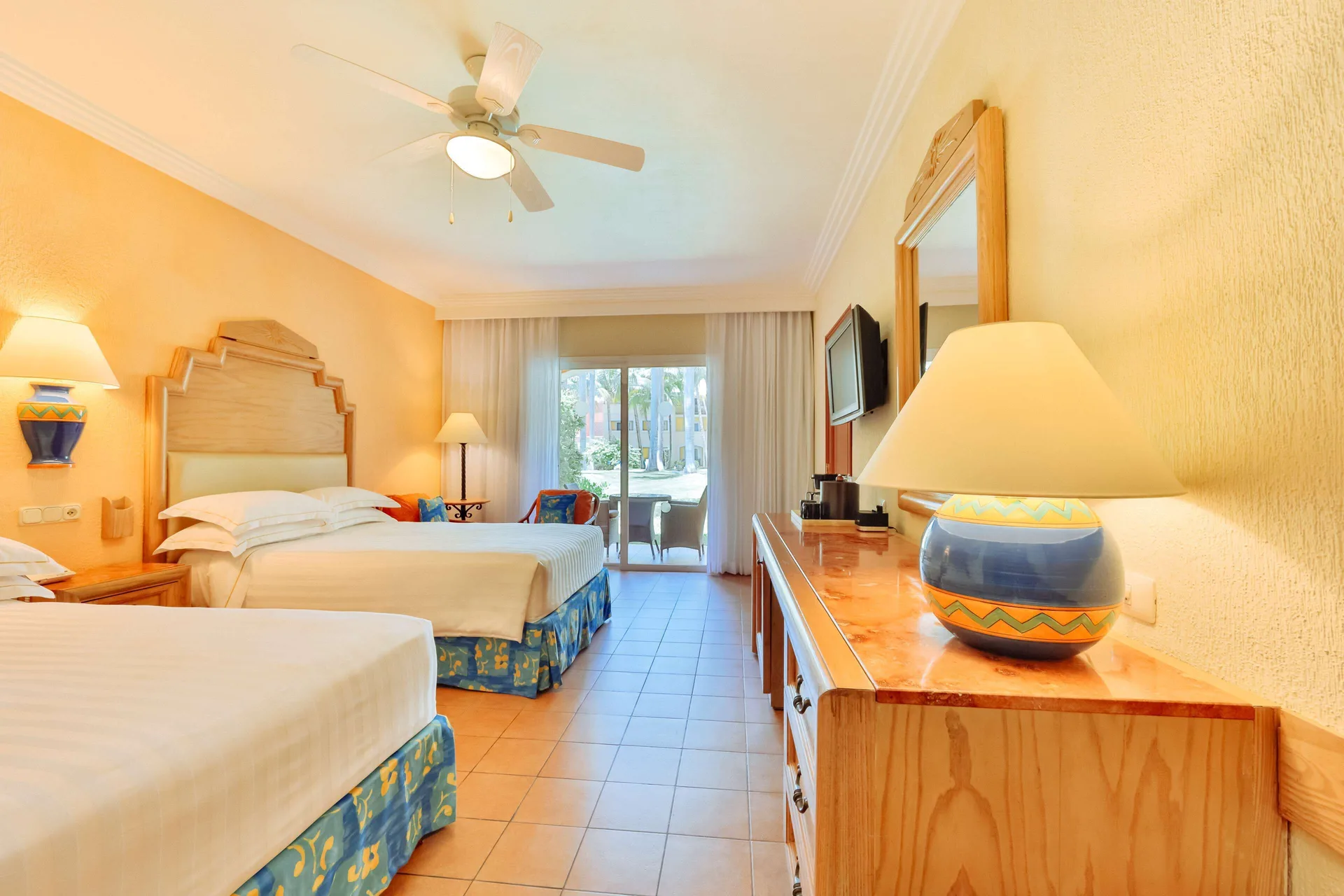 Superior Room with two beds, dresser, and garden-facing doors at Barceló Maya Caribe.