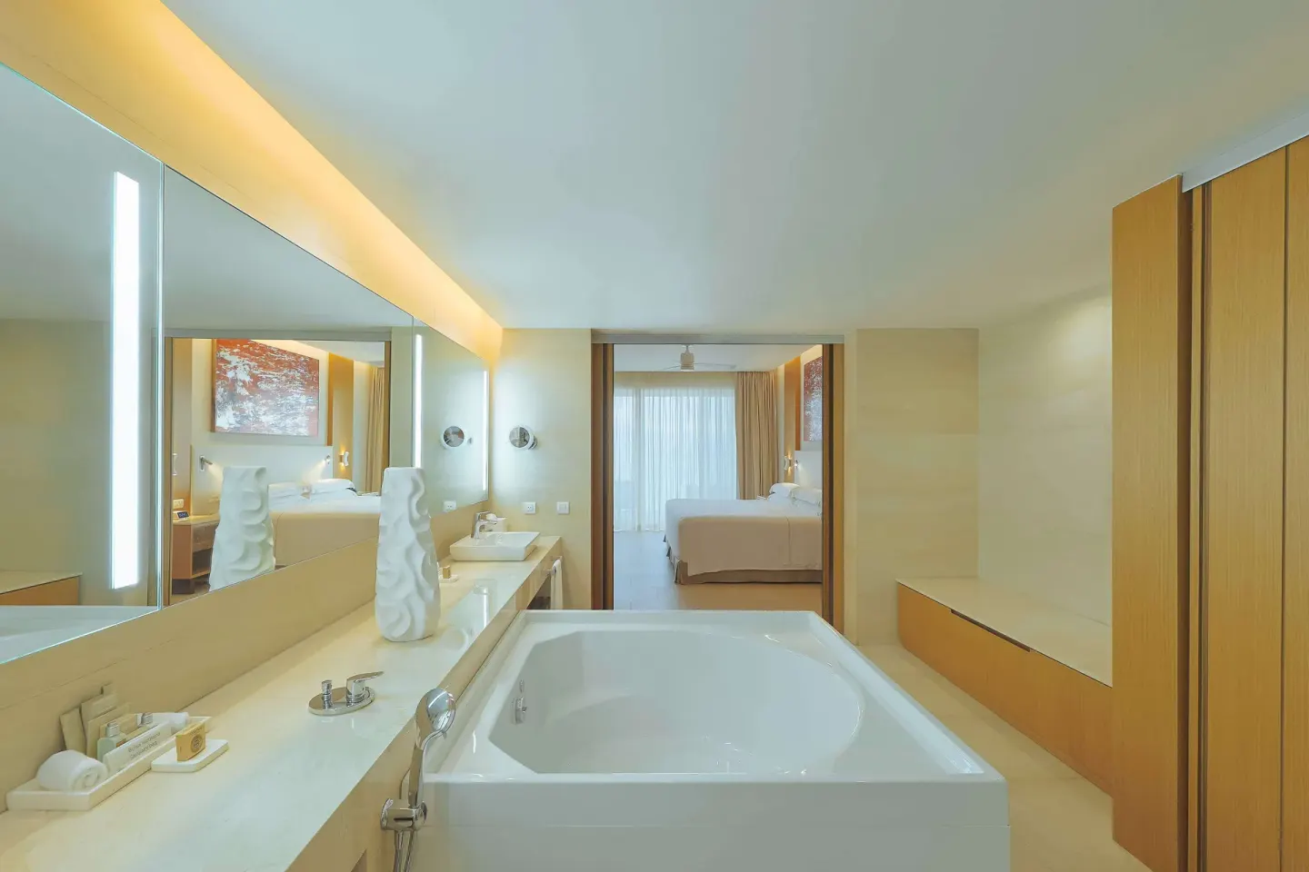 Guest bathroom with soaking tub and bedroom doorway at Barceló Maya Riviera.