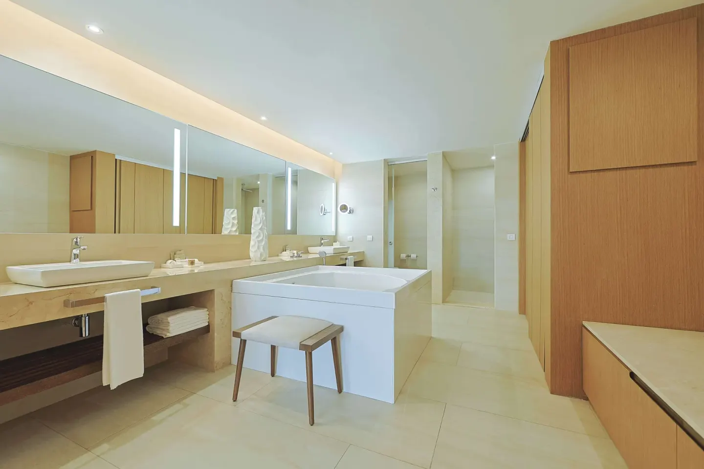 Bright guest bathroom with soaking tub, vanity, stool, and shower at Barceló Maya Riviera.