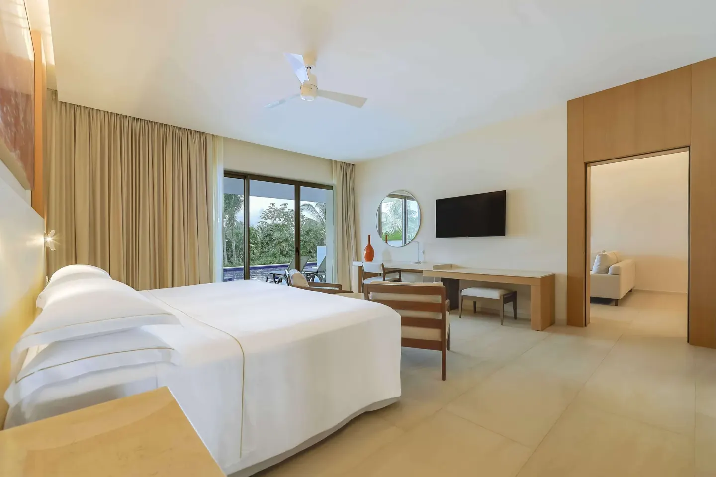 King bedroom with desk, TV, and terrace opening to greenery at Barceló Maya Riviera.