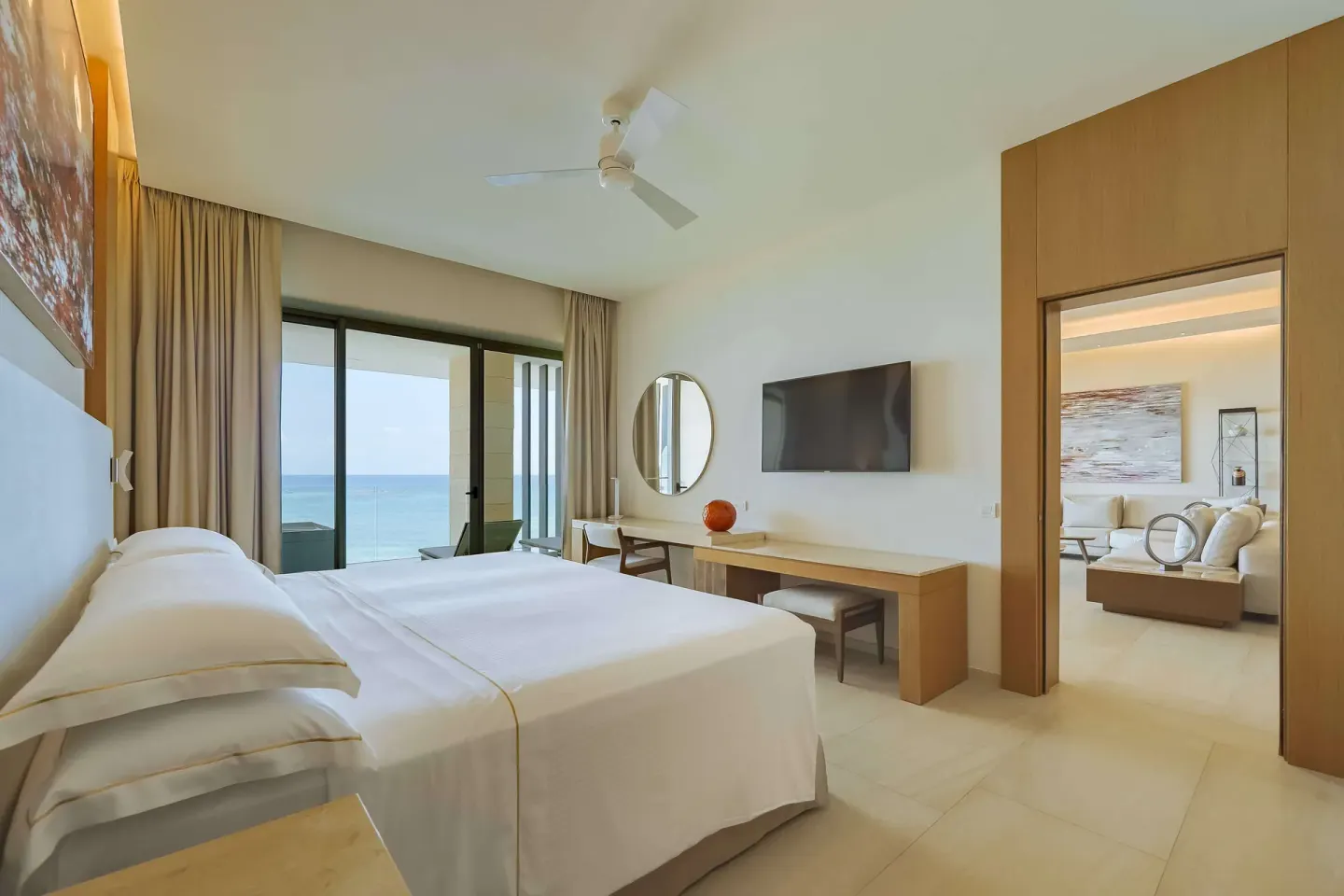 King bedroom with ocean-facing balcony and sitting area at Barceló Maya Riviera.