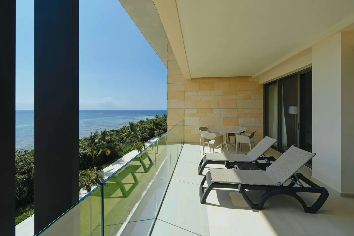 Oceanfront balcony with loungers and dining table at Barceló Maya Riviera.