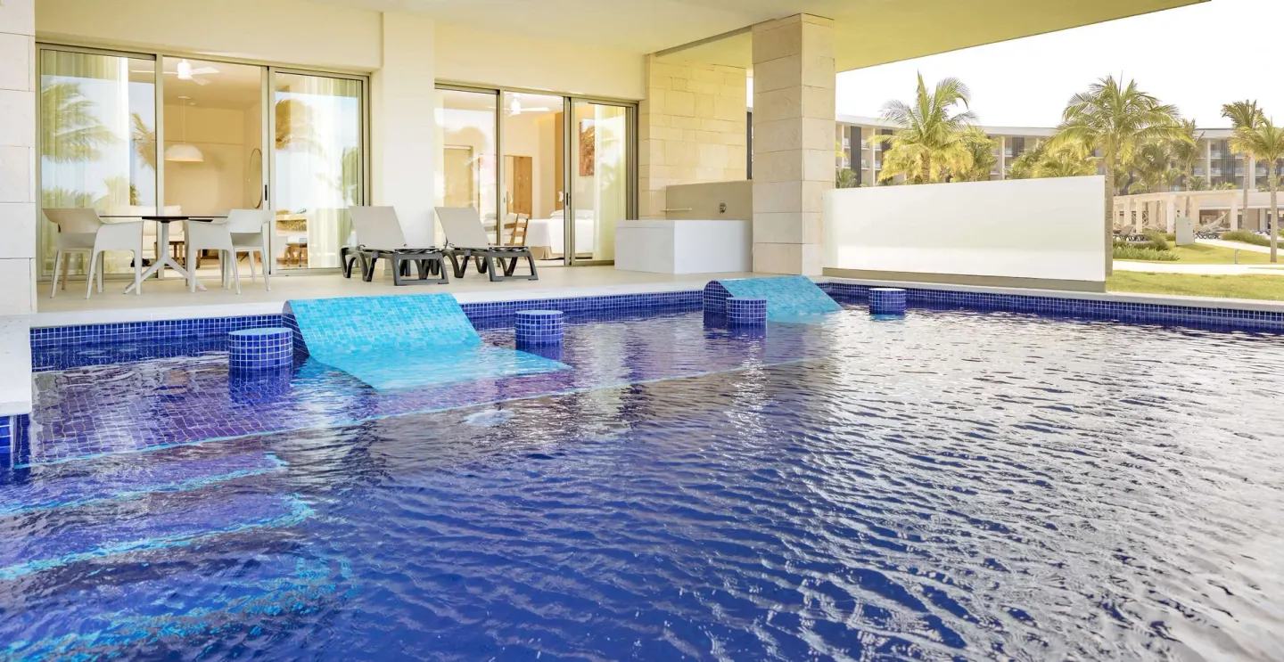 Swim-up terrace pool with loungers outside a suite at Barceló Maya Riviera.