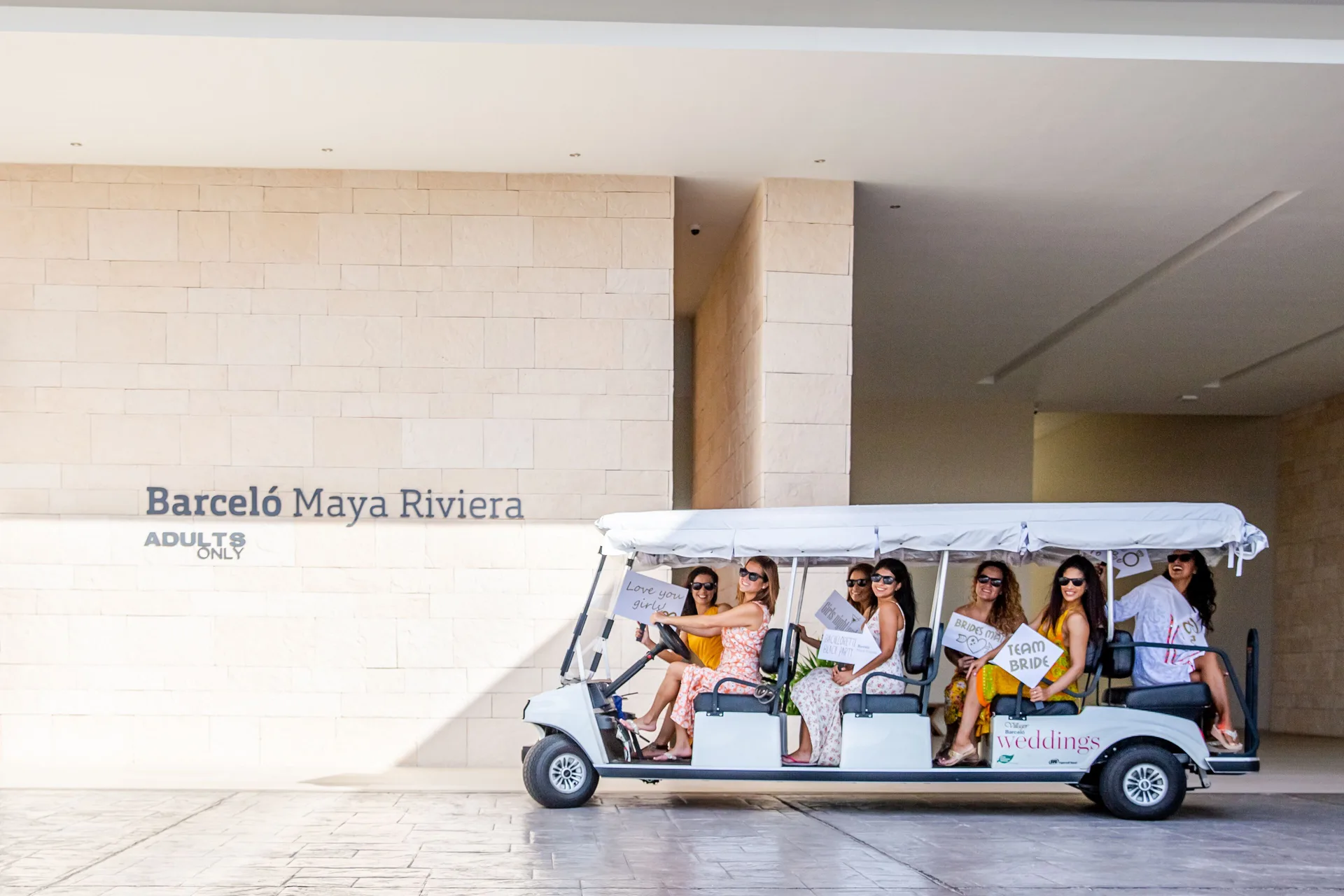 Bridal party riding a resort cart at the Barceló Maya Riviera entrance.