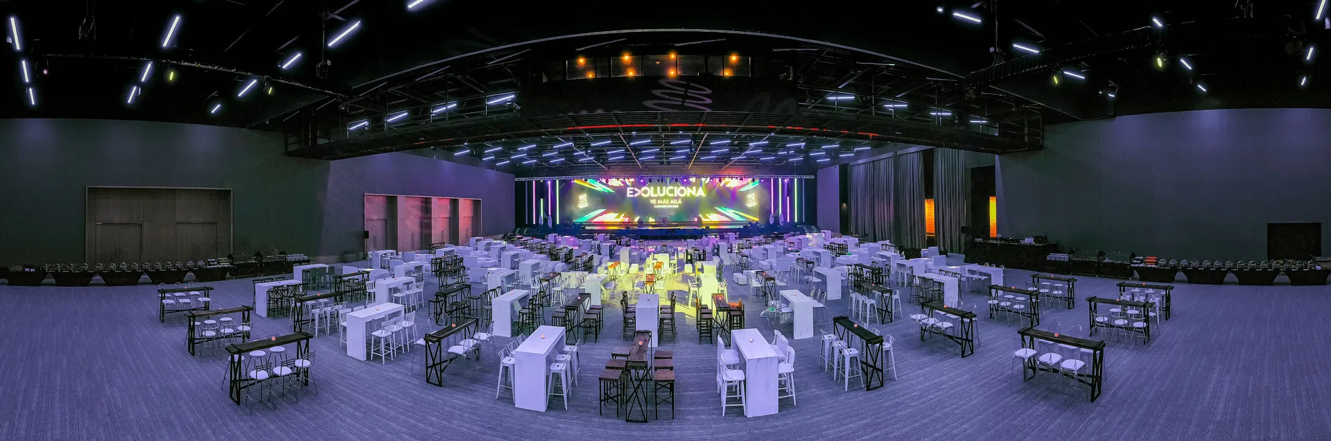 Event hall with stage lighting and banquet tables at Barceló Maya Riviera.