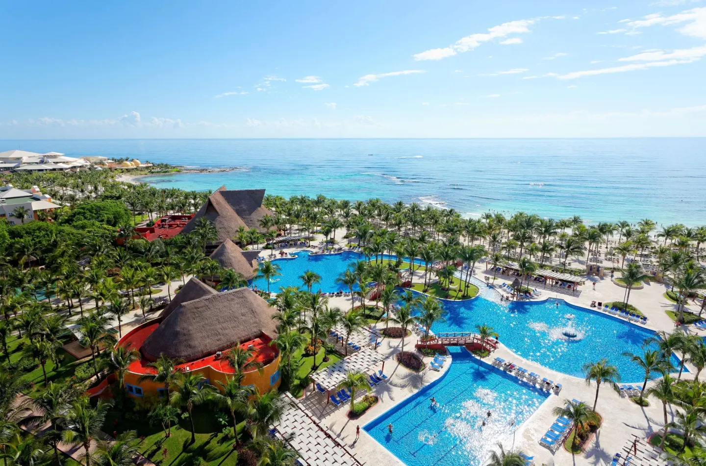 An aerial view shows pools, palm trees, and the beach at Barceló Maya Tropical.