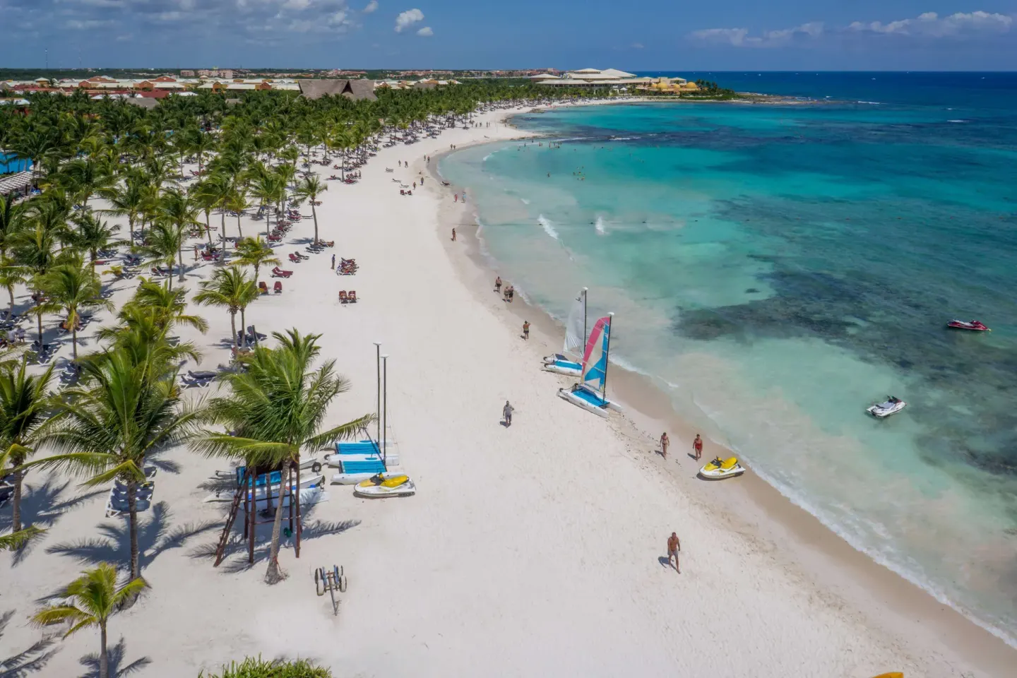 Aerial view of the palm-lined beach with boats at Barceló Maya Tropical.