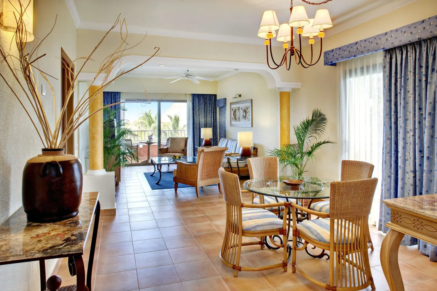 Spacious suite living and dining area with balcony doors at Barceló Maya Tropical.