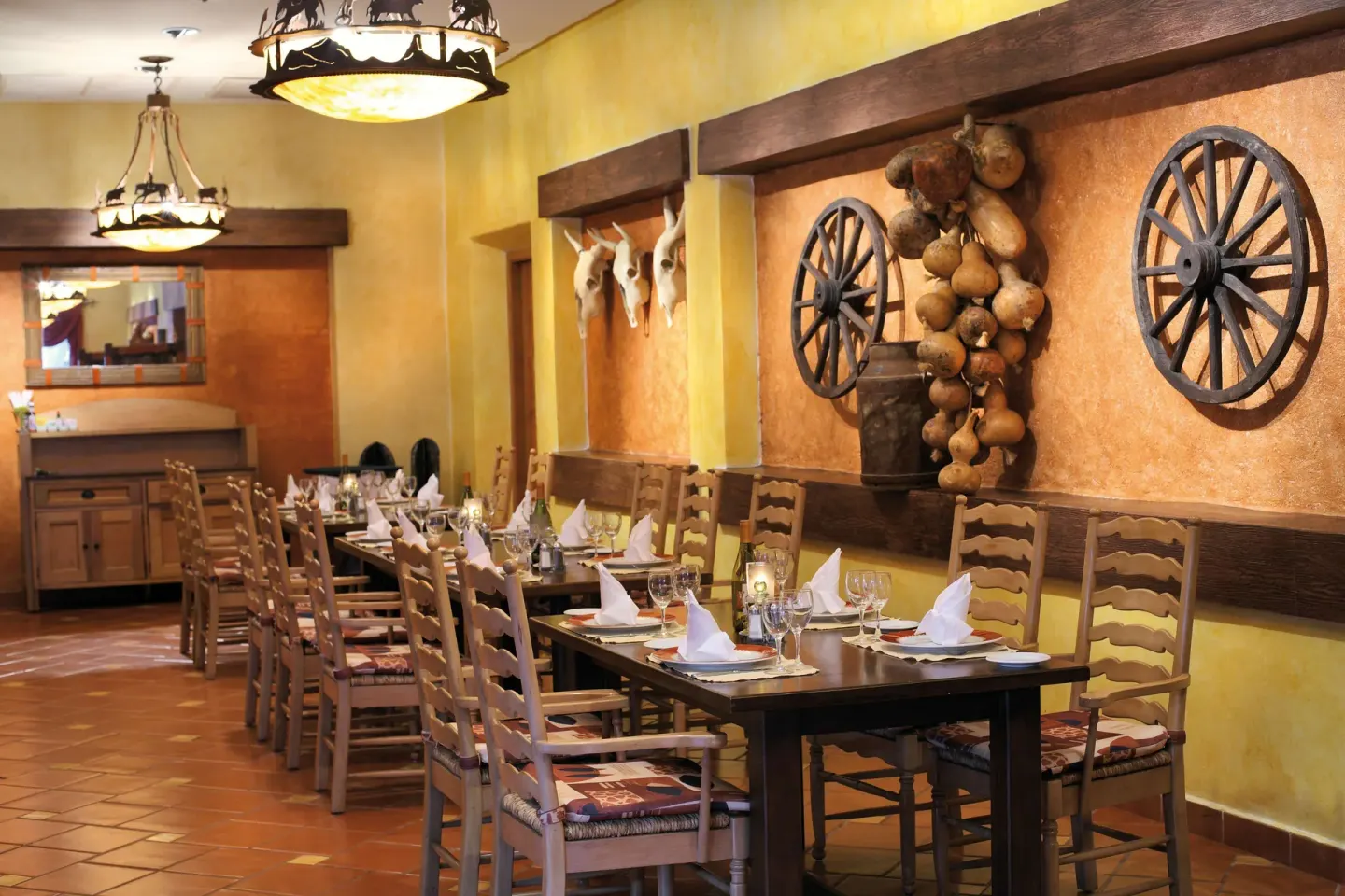Rustic restaurant tables with wagon wheel decor at Barceló Maya Tropical.