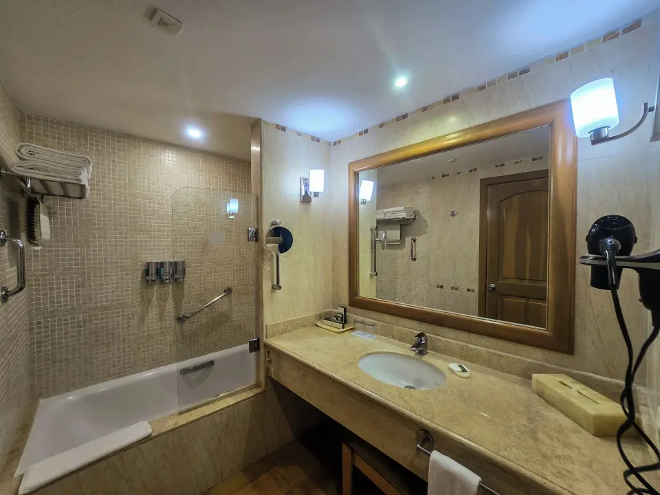 Junior Suite Oceanfront bathroom with tub-shower and vanity at Barceló Maya Tropical.