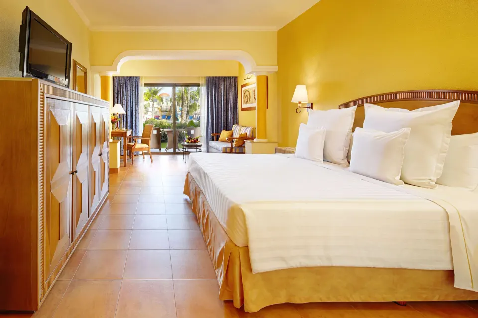 Junior Suite Oceanfront king bed room with seating area at Barceló Maya Tropical.