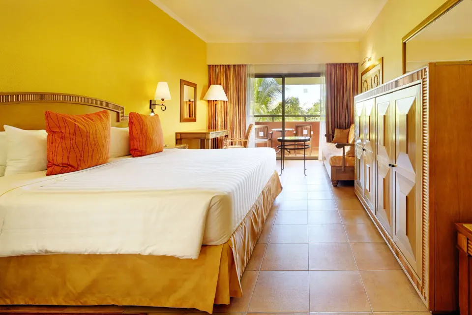 Superior Room king bed with balcony seating at Barceló Maya Tropical.
