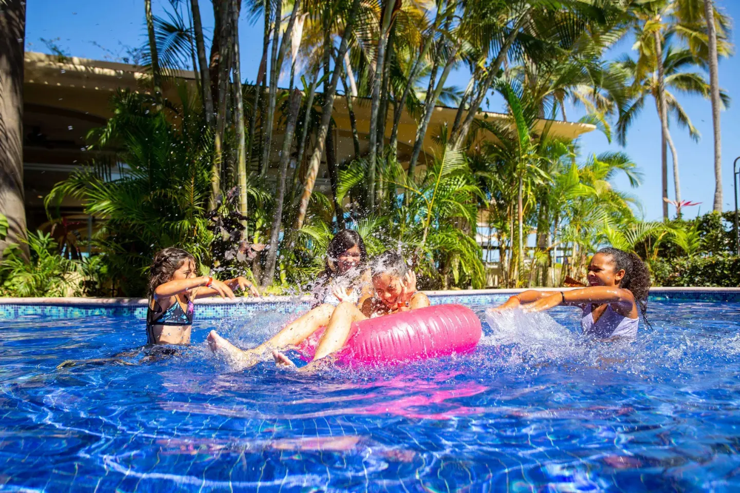 Children splash in the pool with a pink float at Barceló Puerto Vallarta.