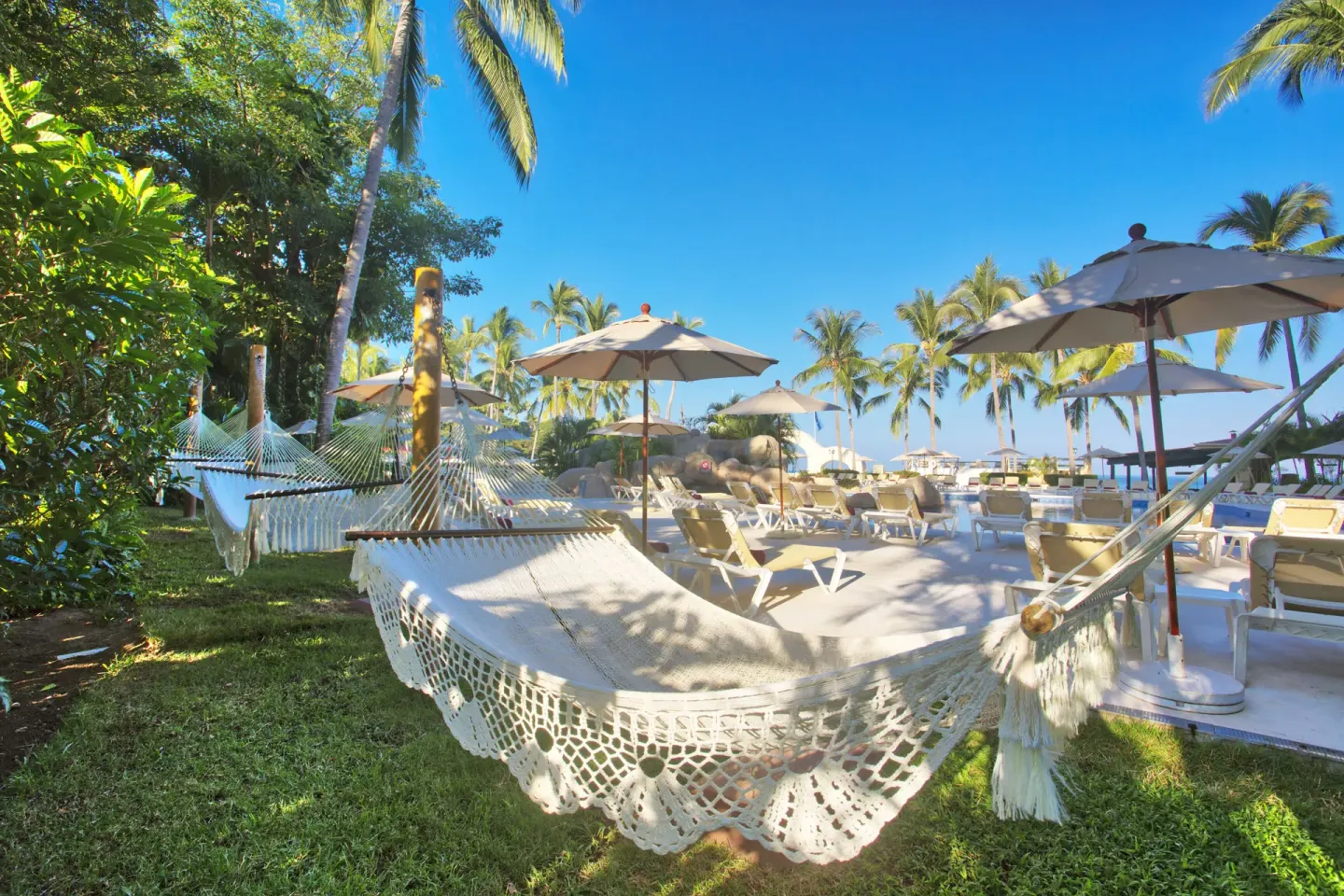 A hammock hangs beside lounge chairs and umbrellas at Barceló Puerto Vallarta.